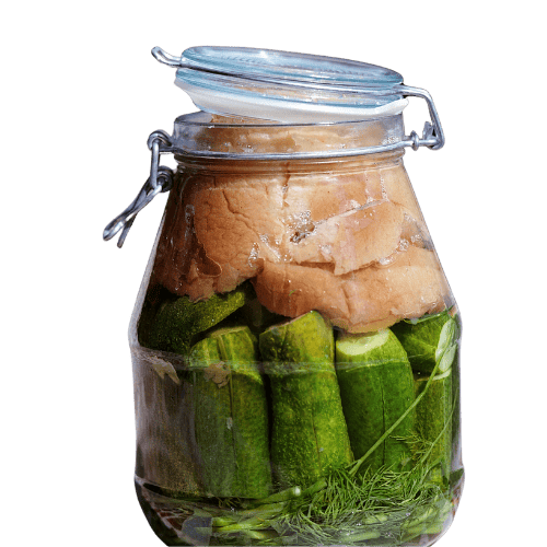 pickled cucumbers A clear glass jar filled with vertically packed pickling cucumbers, sprigs of dill, and topped with slices of bread for traditional fermentation. The jar is sealed with a hinged lid, slightly ajar, showing the brine covering the ingredients.